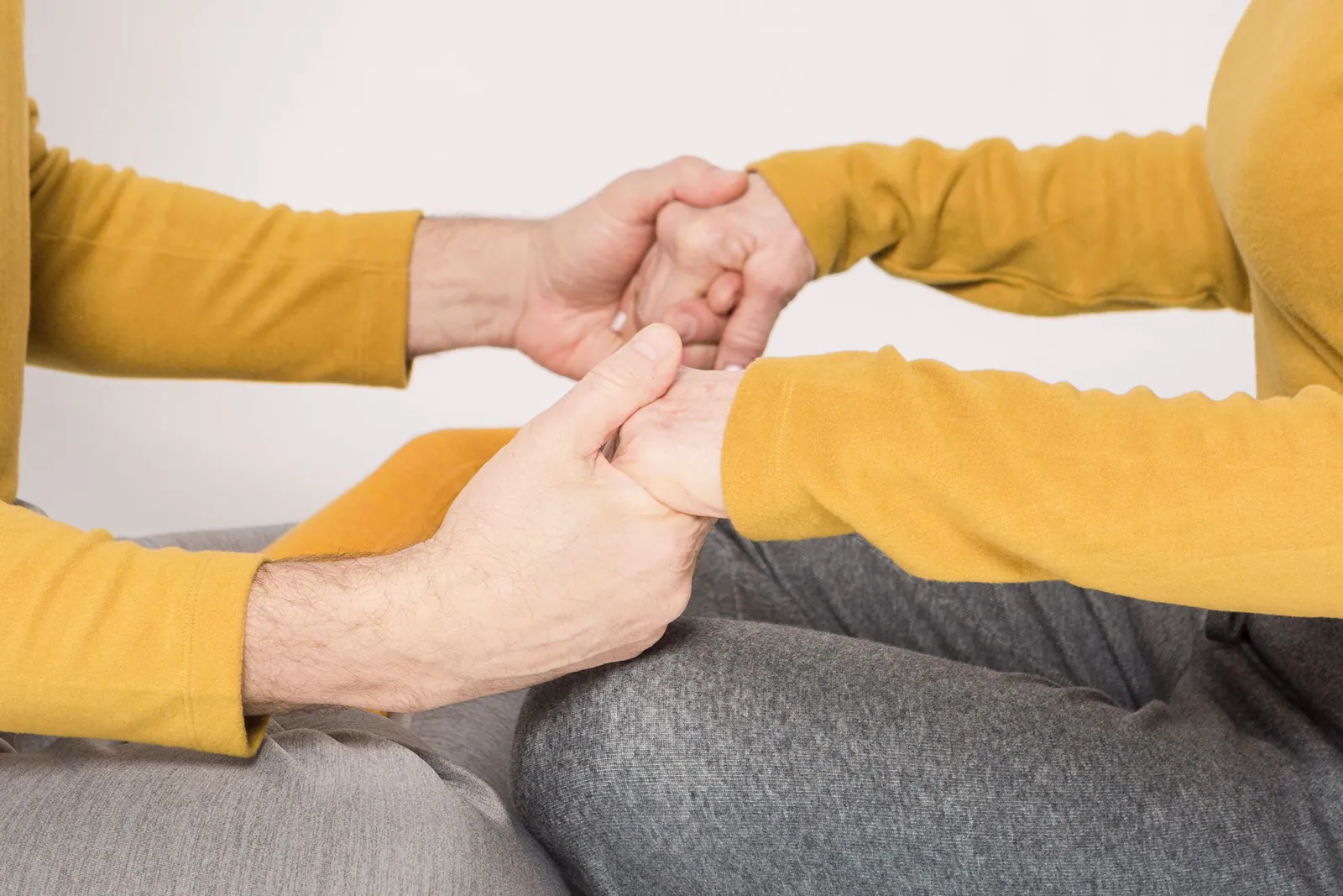 Two adults holding hands in support, representing compassion, patience, and practical biblical love